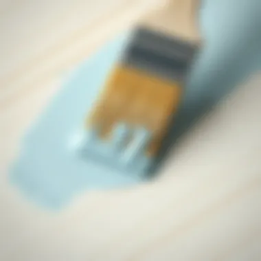 A close-up of a brush applying paint on a smooth MDF surface.